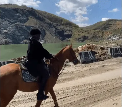 Göl kıyısındaki toprak yolda doru atla binici