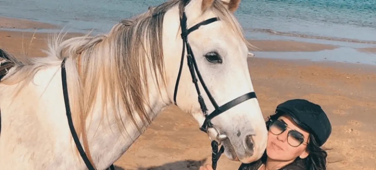 Rider posing with a white horse on a Black Sea beach